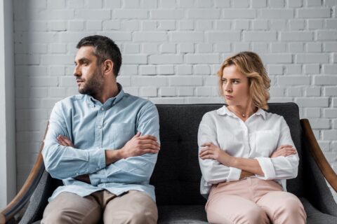 Angry couple sitting on a couch after an argument