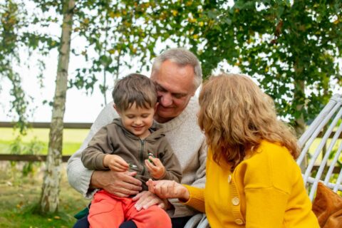 Two grandparents holding their grandchild